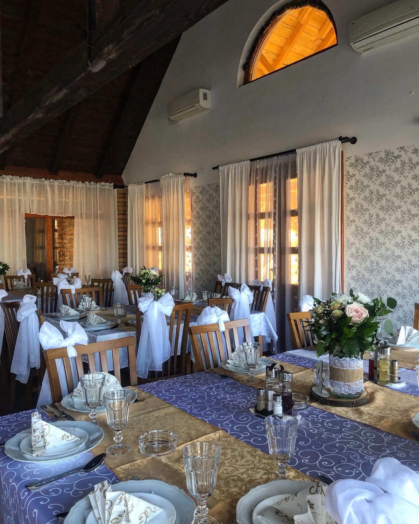 Unutrašnjost rustikalne trpezarije sa drvenim nameštajem i toplim svetlom